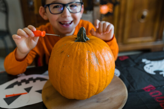 Cheerful child with fresh Halloween pumpkin