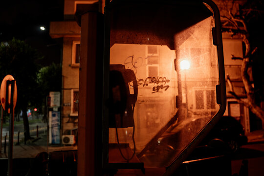 Old phone booth in dark street at night