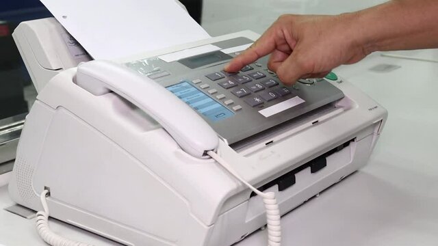 hand man are using a fax machine in the office, equipment for data transmission