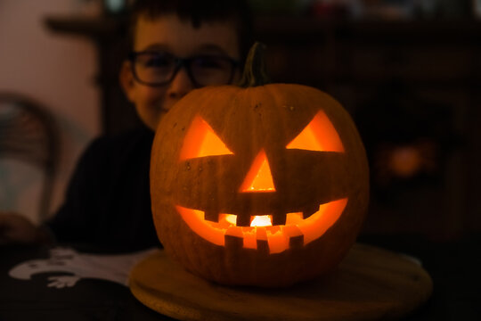 Cute kid with illuminated pumpkin on Halloween