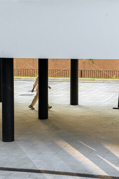 unrecognizable person steps between the columns