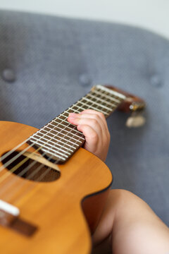 Boy holiding a small guitar's neck