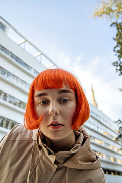 portrait of young red-haired woman against architecture background