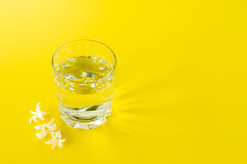 a glass of pure water on yellow background. copy space for text. consept of health life and diet
