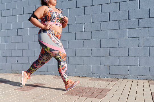 Full-figured woman running on a sidewalk - Powered by Adobe