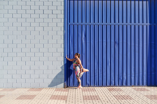 Full-figured woman stretching her legs before a run