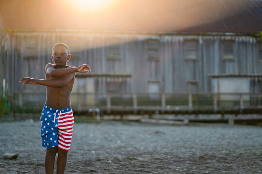 Boy in flag swimsuit swinging arms