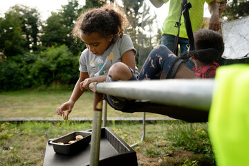 Curly haired girl on trampoline reaches for cookie sandwich