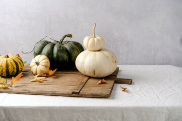 Multiple, colorful pumpkins on a linen tablecloth