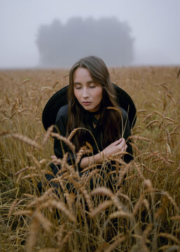 asian girl posing in wheat field in black dress