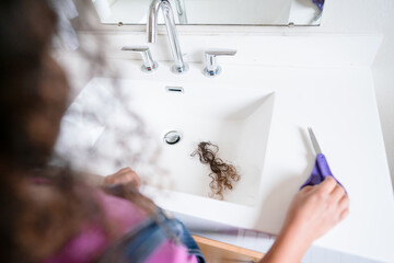Bathroom vanity with clump of shorn curls and scissors