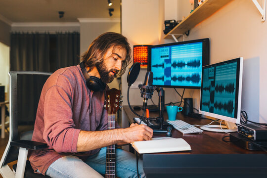 Young man recording music at home music studio