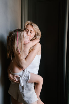 Daughter kissing mother in corridor