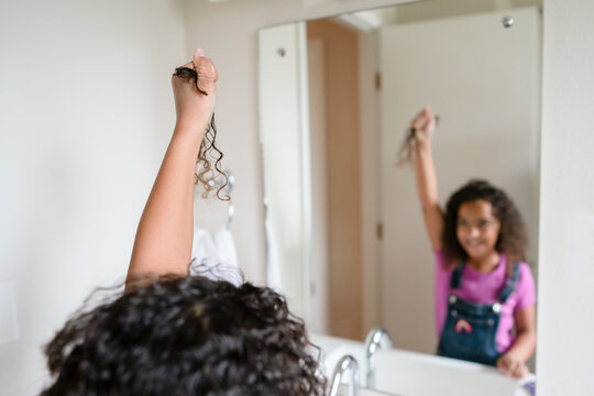 Girl hold chopped off curls in raised hand