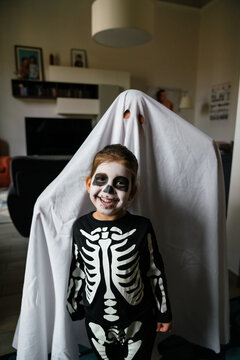 Happy kids in Halloween costumes at home