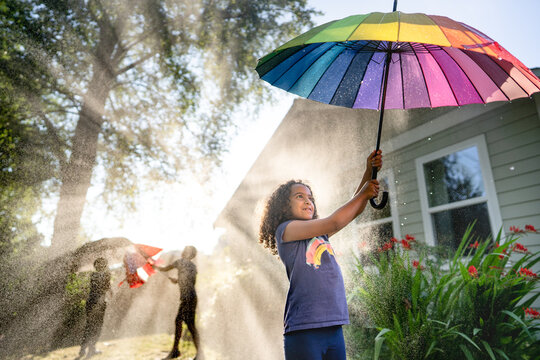 Girl holding up rainbow umbrella