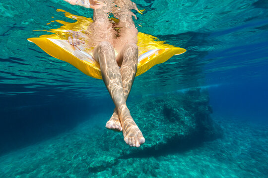 Woman relaxing on a lilo cooling her feet