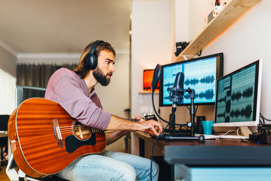 Young man recording music at home music studio