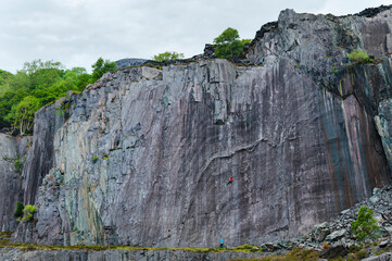 Climber balancing on slab colorful wall in slate quarry