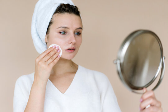 Woman removing makeup with cotton pad