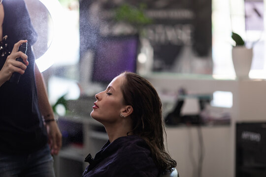 Hairdresser spraying her client's hair