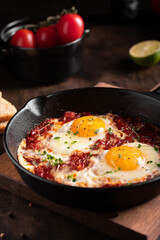 Israel traditional food shakshouka with micro greens in a cast-iron pan
