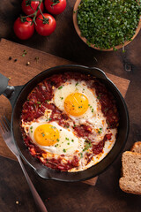 Israel traditional food shakshouka with micro greens in a cast-iron pan
