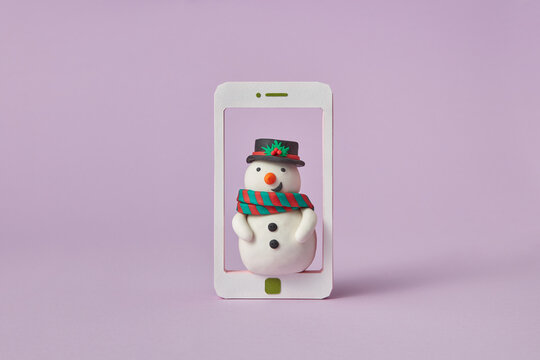 Handmade plasticine Snowman in a smatrphone frame.
