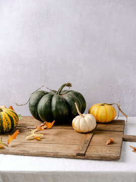 Multiple, colorful pumpkins on a linen tablecloth