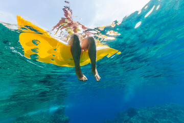 Woman relaxing on a lilo cooling her feet