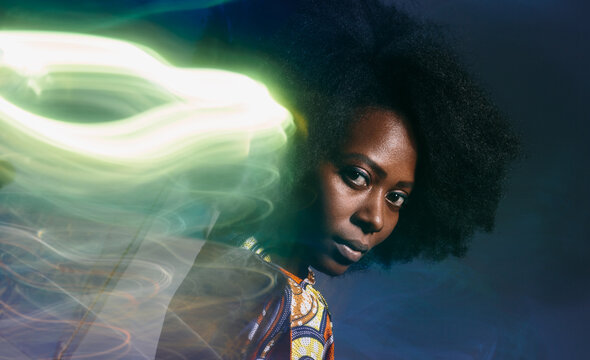 Calm black woman in dark studio