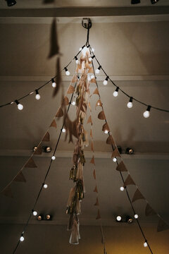 close up of string lights and flag line hanging on a roof for a wedding party