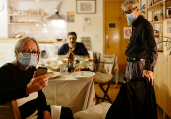 Woman video chatting with a family member at home at night after family holiday dinner.