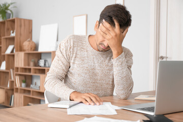 Portrait of stressed young man at home