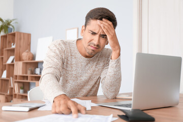 Portrait of stressed young man at home