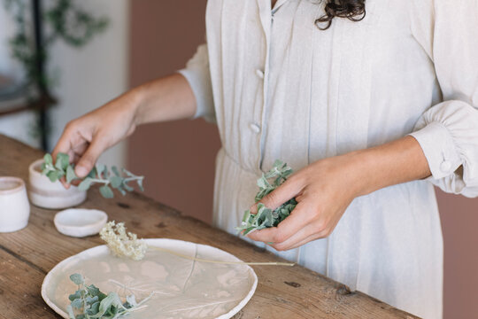 Woman decorating a plate with herb twigs