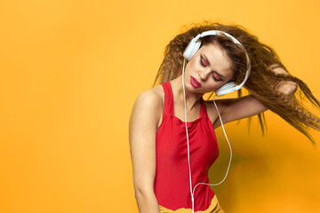 Cheerful woman in headphones music lifestyle yellow background