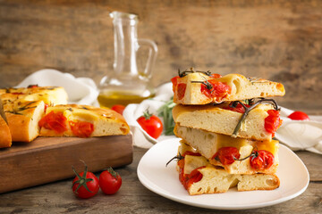 Plate with traditional Italian focaccia on wooden background