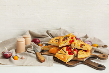 Composition with traditional Italian focaccia on light wooden background