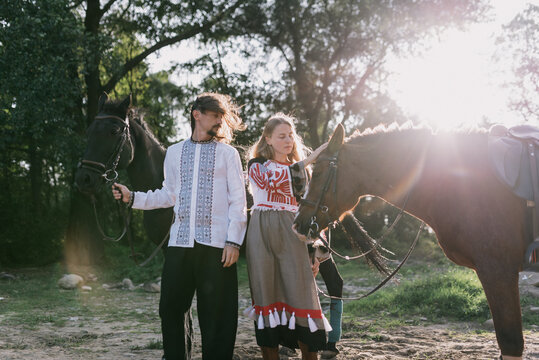 Young couple an two horses in a traditional costumes
