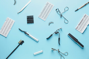 Composition with false eyelashes and tools on color background
