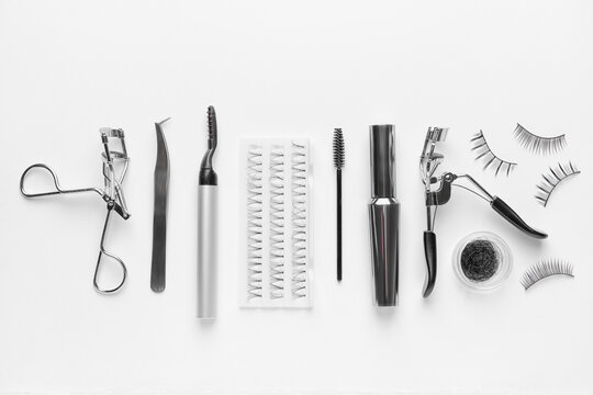 Composition with false eyelashes and tools on white background