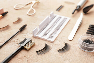 Composition with false eyelashes and tools on color background, closeup