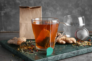 Cup of aromatic black tea on dark background