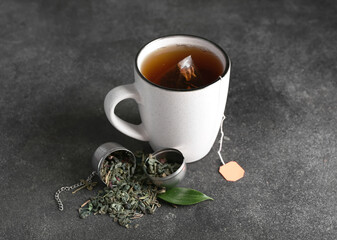 Cup of aromatic black tea on dark background