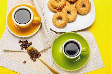 Cups of hot coffee on color background