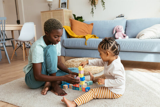 Mother and kid playing with colorful blocks