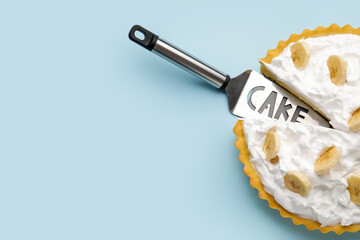Tasty banana pie and spatula on color background