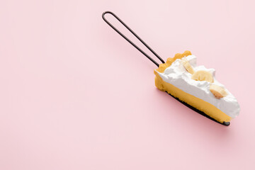 Spatula with piece of tasty banana pie on color background