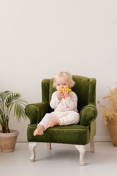 Cute girl in armchair in living room